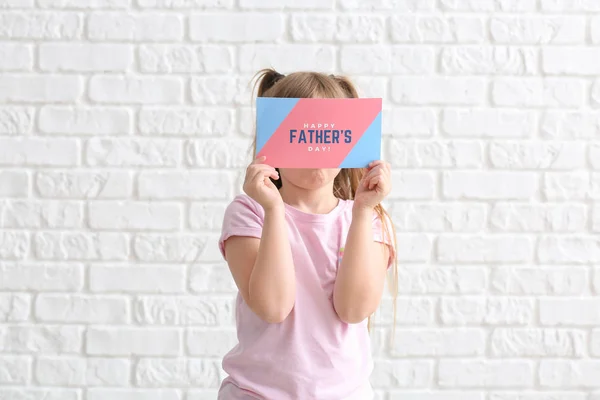 Schattig klein meisje met wenskaart voor vaderdag op witte achtergrond — Stockfoto