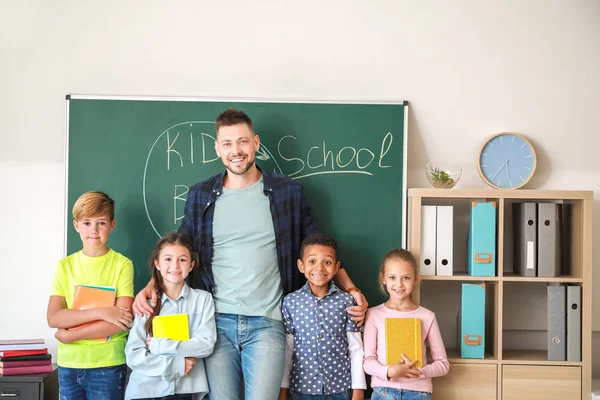 Schattige kinderen met leraar in klaslokaal — Stockfoto