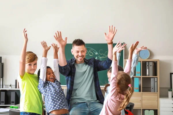Happy children with teacher in classroom — Stock Photo, Image