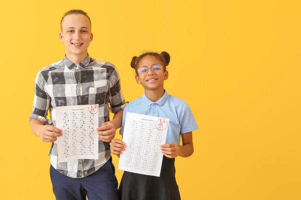 Compagni di classe felici con risultati del test scolastico su sfondo a colori — Foto Stock