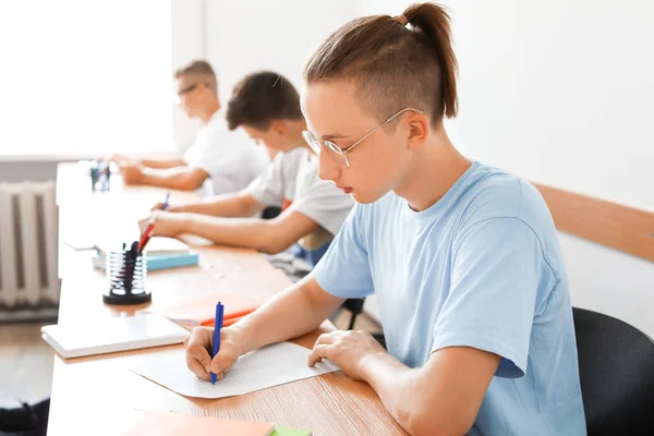 Alunos passando no teste escolar em sala de aula — Fotografia de Stock