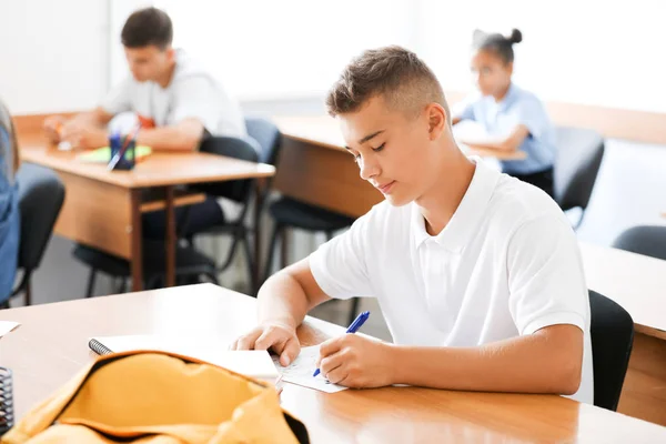 Adolescente chico pasando prueba de escuela en el aula — Foto de Stock