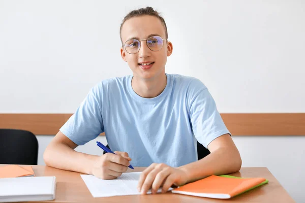 Tonårs pojke passerande skola prov i klassrummet — Stockfoto