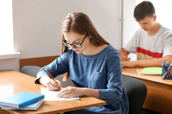 Menina adolescente passando no teste da escola em sala de aula — Fotografia de Stock