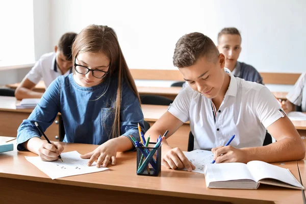 Pupils passing school test in classroom — Stock Photo, Image