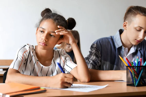 Alunos passando no teste escolar em sala de aula — Fotografia de Stock