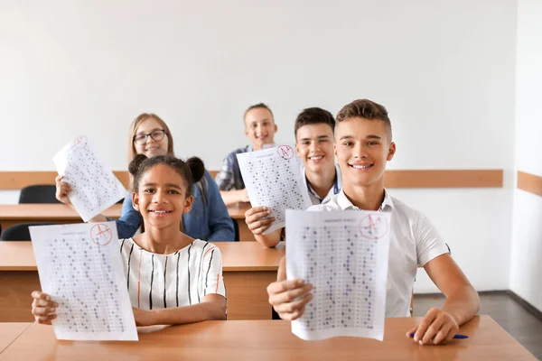 Colegas felizes com resultados de teste escolar em sala de aula — Fotografia de Stock