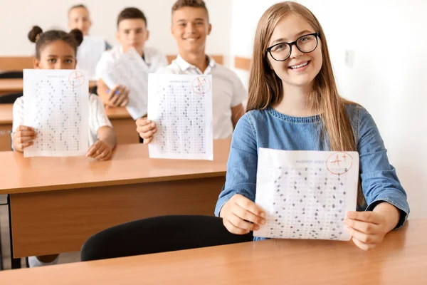 Glückliches Mädchen mit Ergebnissen des Schultests im Klassenzimmer — Stockfoto