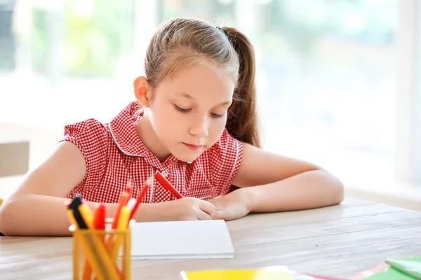 Cute little girl during lesson in classroom — Stock Photo, Image