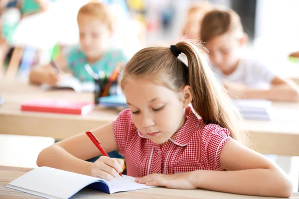 Menina bonito durante a aula em sala de aula — Fotografia de Stock