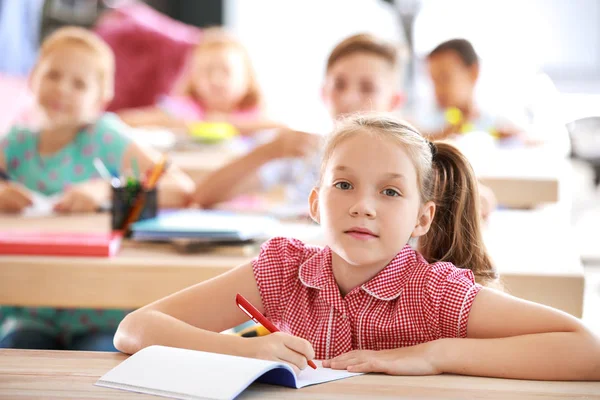 Menina bonito durante a aula em sala de aula — Fotografia de Stock