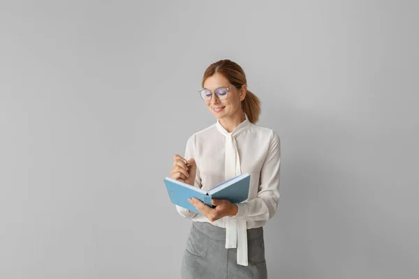 Hermosa profesora con libro sobre fondo claro — Foto de Stock