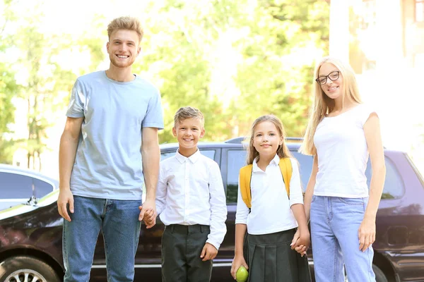 Ouders met hun kleine kinderen in de buurt van de auto voordat ze naar school gaan — Stockfoto