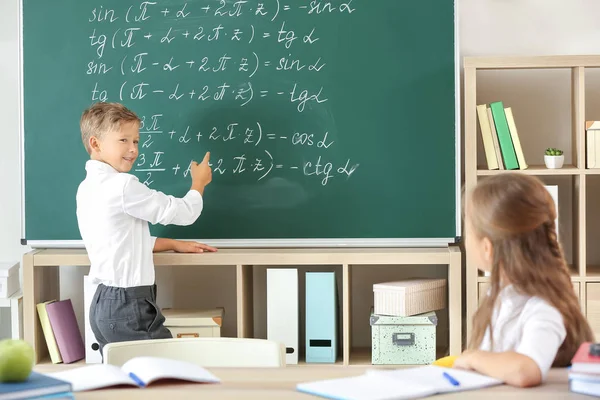 Menino perto do quadro-negro da escola em sala de aula — Fotografia de Stock