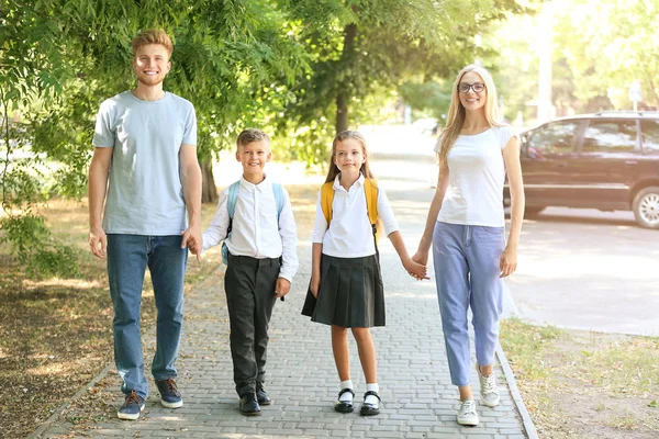 Crianças pequenas indo para a escola com seus pais — Fotografia de Stock