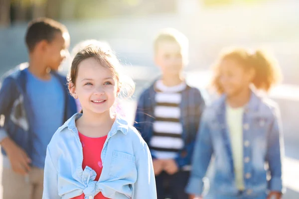 Happy little girl with friends outdoors — Stock Photo, Image