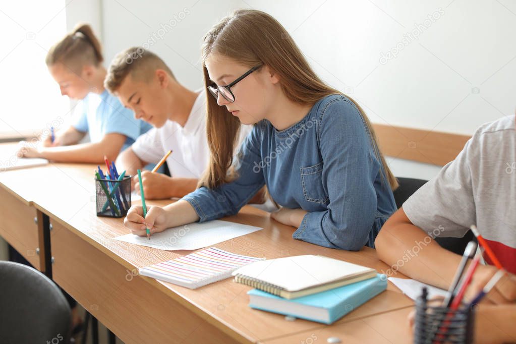 Pupils passing school test in classroom