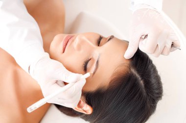 Güzellik salonunda kaş düzeltme ameliyatı olan genç bir kadın.