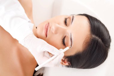 Güzellik salonunda kaş düzeltme ameliyatı olan genç bir kadın.