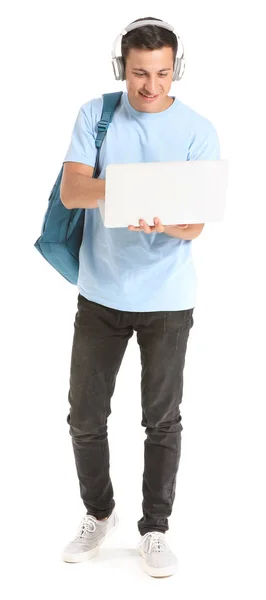 Retrato de jovem estudante com laptop e fones de ouvido em fundo branco — Fotografia de Stock