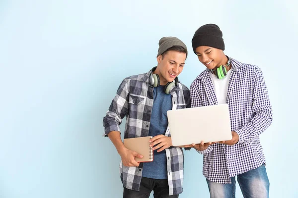 Portrait de jeunes étudiants avec ordinateur portable sur fond de couleur — Photo