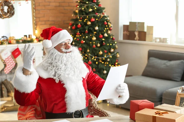 Papai Noel lista de desejos de leitura no quarto decorado para o Natal — Fotografia de Stock