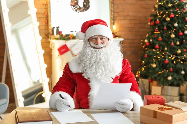 Jultomten läser önskelista i rum inredda för jul — Stockfoto