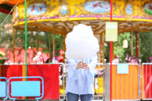Woman with sweet cotton candy in amusement park — Stock Photo, Image