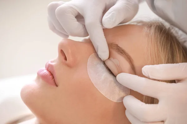 Young woman undergoing procedure of eyelashes lamination in beauty salon, closeup — Stock Photo, Image