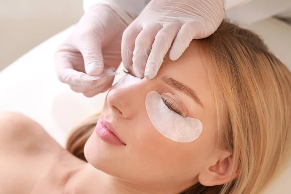 Young woman undergoing procedure of eyelashes lamination in beauty salon — Stock Photo, Image