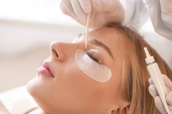 Young woman undergoing procedure of eyelashes lamination in beauty salon, closeup — Stock Photo, Image