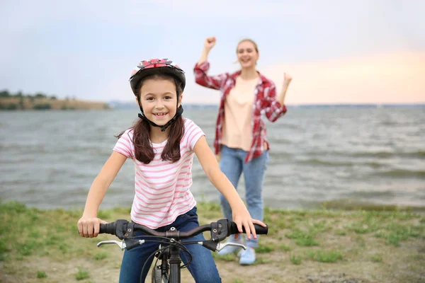 Mother proud of her daughter who learned to ride bicycle outdoors — Stock Photo, Image