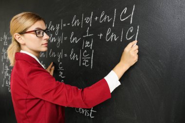 Sınıfta kara tahta yakınında güzel matematik öğretmeni