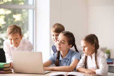 Sınıfta dizüstü bilgisayar ile sevimli küçük öğrenciler