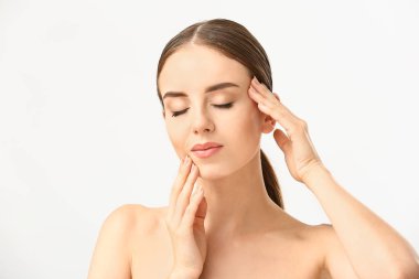 Güzel kadın beyaz arka plan karşı yüzünü masaj