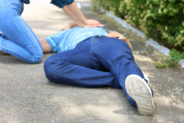 Femme donnant CPR à l'homme inconscient à l'extérieur — Photo