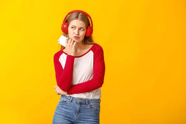 Jeune femme écoutant le livre audio sur fond de couleur — Photo