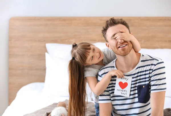 Liten flicka hälsning hennes pappa med fars dag hemma — Stockfoto