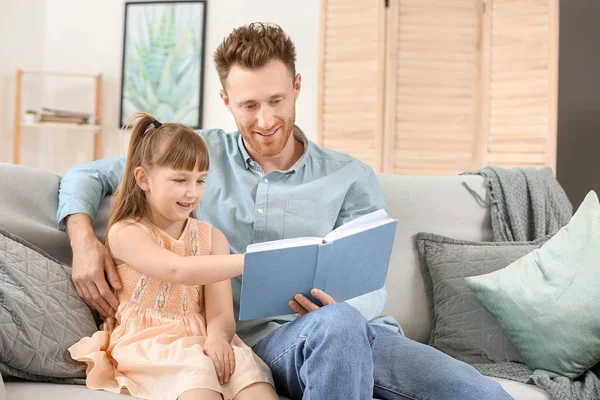 Retrato de pai feliz e sua filha lendo livro em casa — Fotografia de Stock