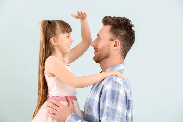 Porträtt av lycklig far och hans lilla dotter på färg bakgrund — Stockfoto