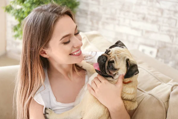 Hermosa mujer joven con lindo perro pug en casa — Foto de Stock