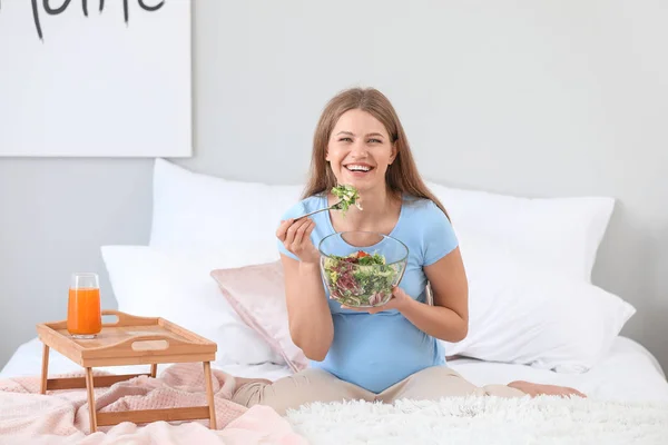 Beautiful pregnant woman having breakfast in bedroom — Stock Photo, Image