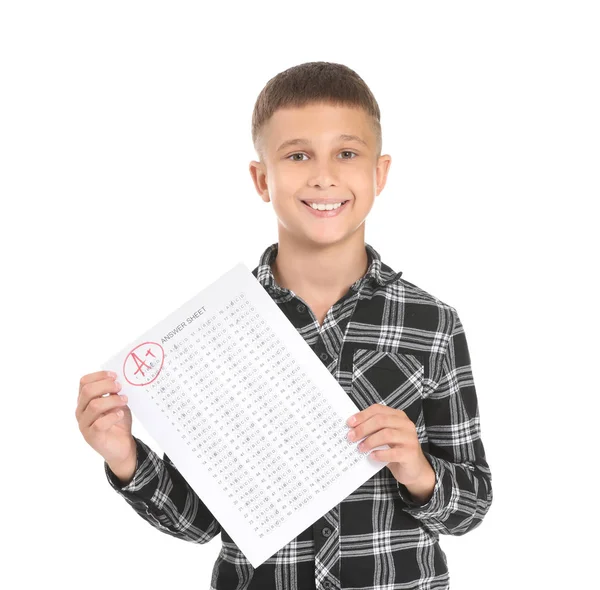 Menino feliz com folha de resposta para teste escolar em fundo branco — Fotografia de Stock