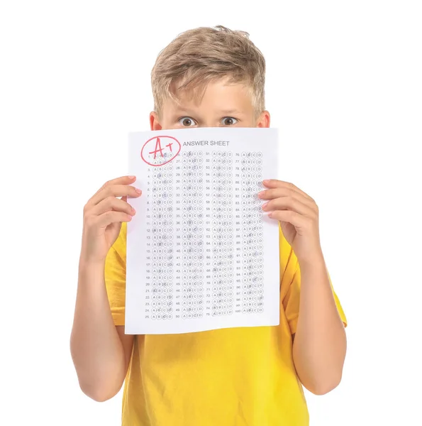 Menino com folha de resposta para teste escolar em fundo branco — Fotografia de Stock