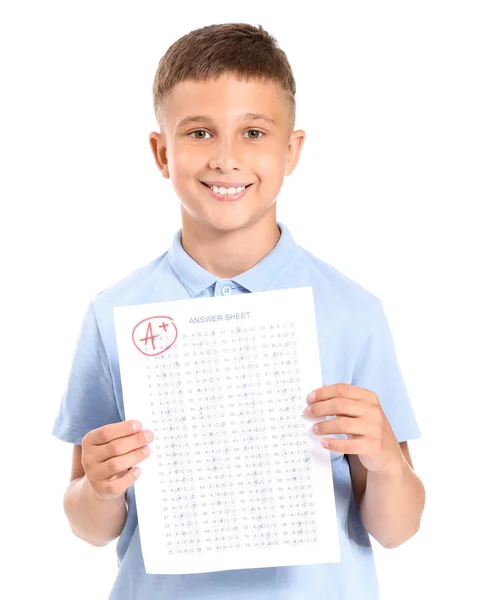 Menino feliz com folha de resposta para teste escolar em fundo branco — Fotografia de Stock