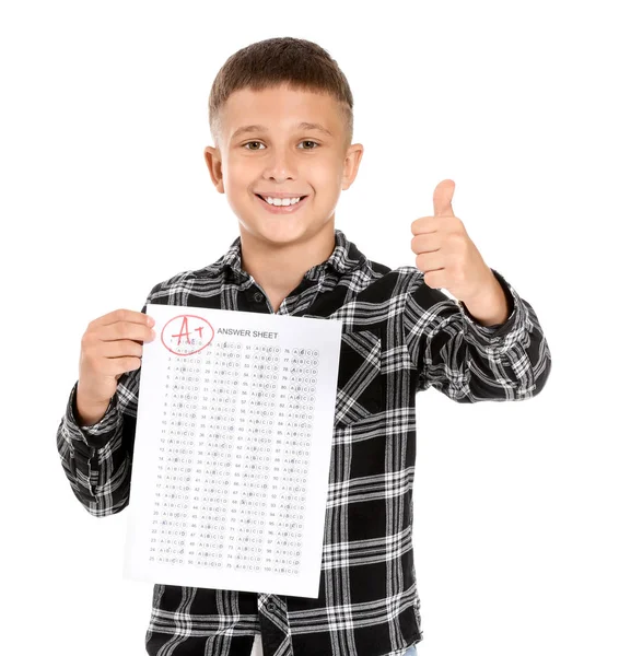 Menino feliz com folha de resposta para teste escolar em fundo branco — Fotografia de Stock