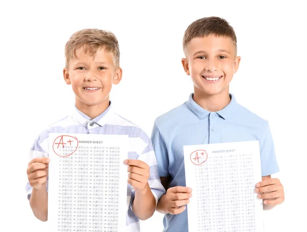 Crianças felizes com folhas de resposta para teste escolar em fundo branco — Fotografia de Stock