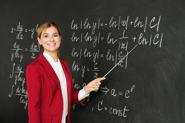 Hermoso profesor de matemáticas cerca de pizarra en el aula — Foto de Stock