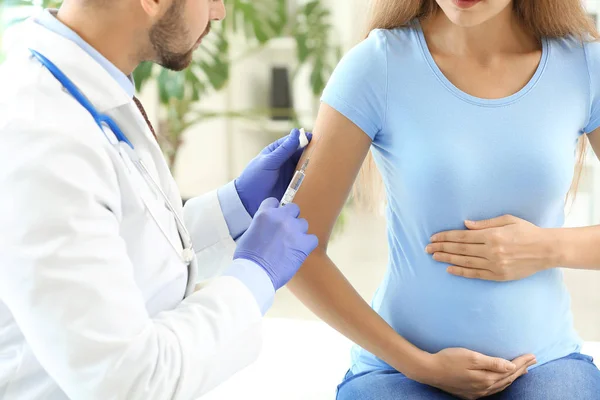 Γιατρός που εμβολιάζει έγκυο γυναίκα στην κλινική — Φωτογραφία Αρχείου