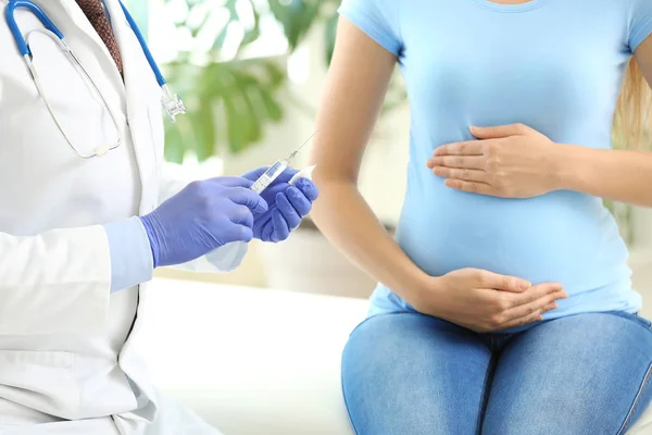 Γιατρός που εμβολιάζει έγκυο γυναίκα στην κλινική — Φωτογραφία Αρχείου